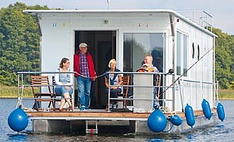 unser Hausboot Febomobil 1180 auf einem See mit einer Familie an Deck