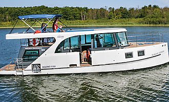 Das elegante chicke Hausboot Hausboot Aquino 1190 fährt über einen See.