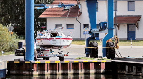 Sportboot am kleinen 3t Kran neben dem 90t Kran von Kuhnle im Hafendorf Müritz.  Boot wird gekrankt und bekommt 2 Wochen Liegeplatz.